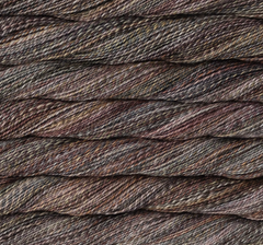 Close-up view of twisted, sport weight Malabrigo Torzal hand-dyed yarn in shades of grey, brown, and tan.