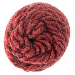 A close-up of a ball of Brown Sheep Lamb's Pride Worsted Yarn shows thick, twisted strands with subtle red color variations, set against a white background.