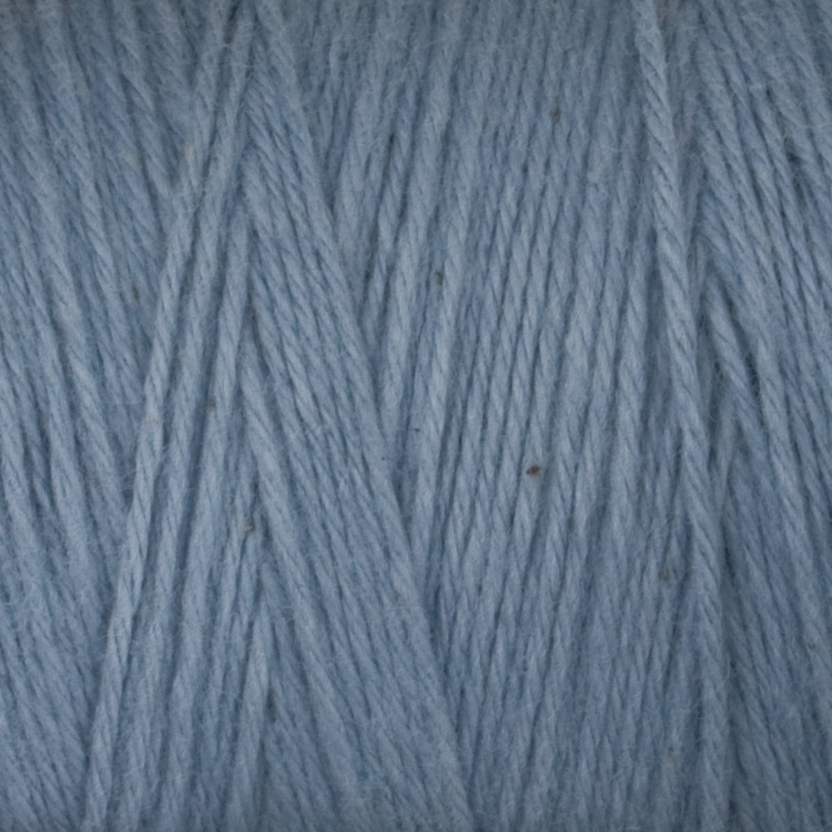Close-up of light blue Cotton Carpet Warp 8/4 by Great Northern Weaving, highlighting the visible strands, fibers, and textured weave of this 4-ply cotton yarn.