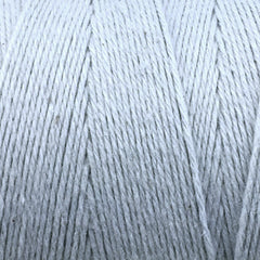 Close-up of Great Northern Weaving's Cotton Carpet Warp 8/4: white 4-ply cotton yarn wound in parallel layers on a spool, highlighting detailed fibers ideal for weaving strong, colorfast cotton yarn rugs.