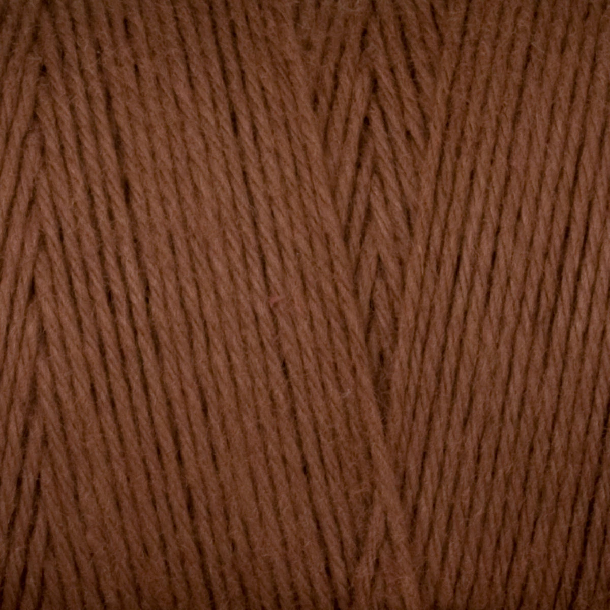 Close-up of Great Northern Weaving Cotton Carpet Warp 8/4 in brown, highlighting the 4-ply cotton fibers twisted together for a soft, even texture.
