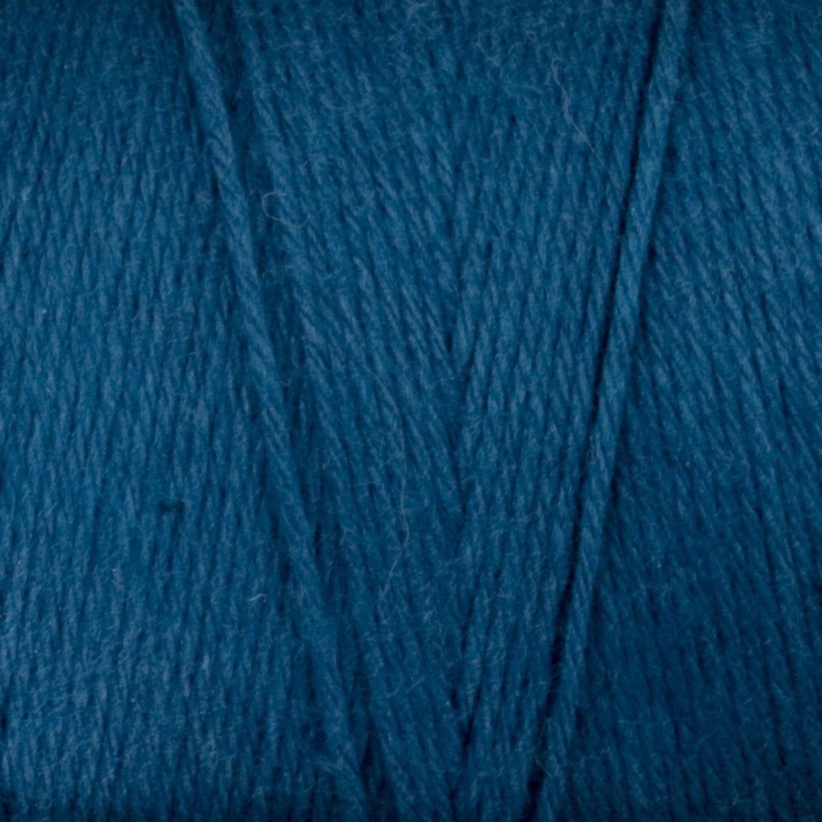 Close-up of Great Northern Weaving Cotton Carpet Warp 8/4 in teal blue, highlighting the texture and fibers of the 4-ply cotton yarn wound into a ball.