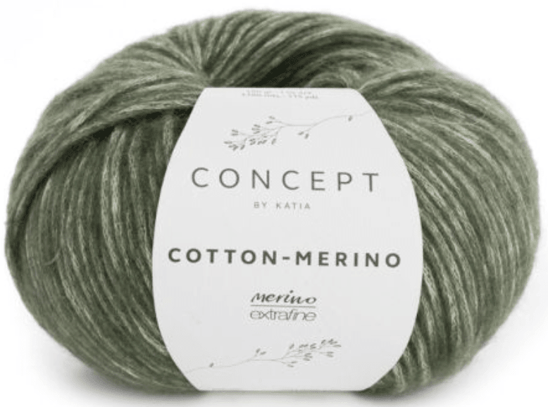 A skein of Katia Cotton-Merino yarn in sage green, combining soft merino and cotton in a chainette structure, is wrapped in a simple white paper band with delicate leaf illustrations and the Katia brand name.