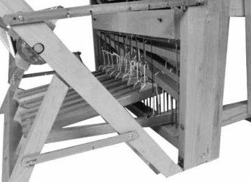 A close-up of the Leclerc Nilus II 8-Shaft Floor Loom by Leclerc Looms shows its wooden frame, metal rods, and strings essential for weaving as a jack loom with back-hinge treadles.