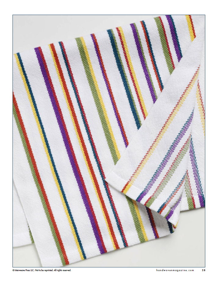 A white towel with diagonal red, yellow, green, purple, and blue stripes is neatly folded—a vibrant example from "Winning Towels from Handwoven's 21st-Century Towel Contest" by Long Thread Media (eBook Printed Version).
