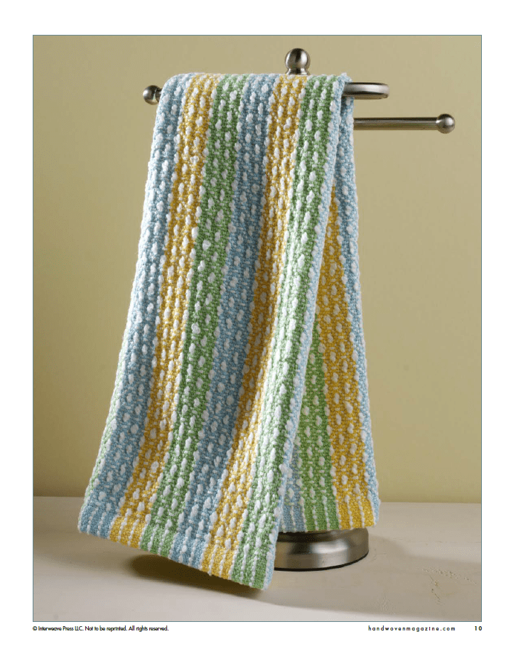A soft, textured handwoven towel with blue, green, yellow, and white stripes hangs neatly—perfect inspiration from Long Thread Media's "Winning Towels from Handwoven's 21st-Century Towel Contest" eBook (Printed Version).
