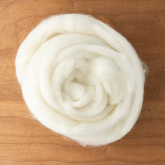 A coiled length of white Corriedale Wool Top by Europa Wools Ltd for spinning yarn on a wooden surface.