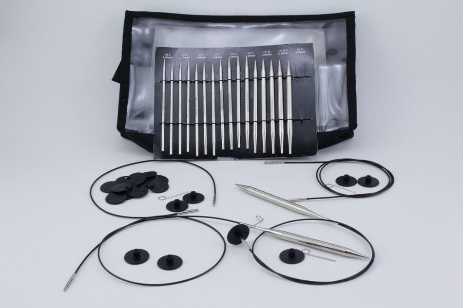 The Accessories Unlimited Knit Pro (Knitters Pride) Nova Metal Interchangeable Circular Knitting Needle Set includes hollow brass needles with silver tips, black cables, end caps, and a zippered pouch for storage, shown on a white background.