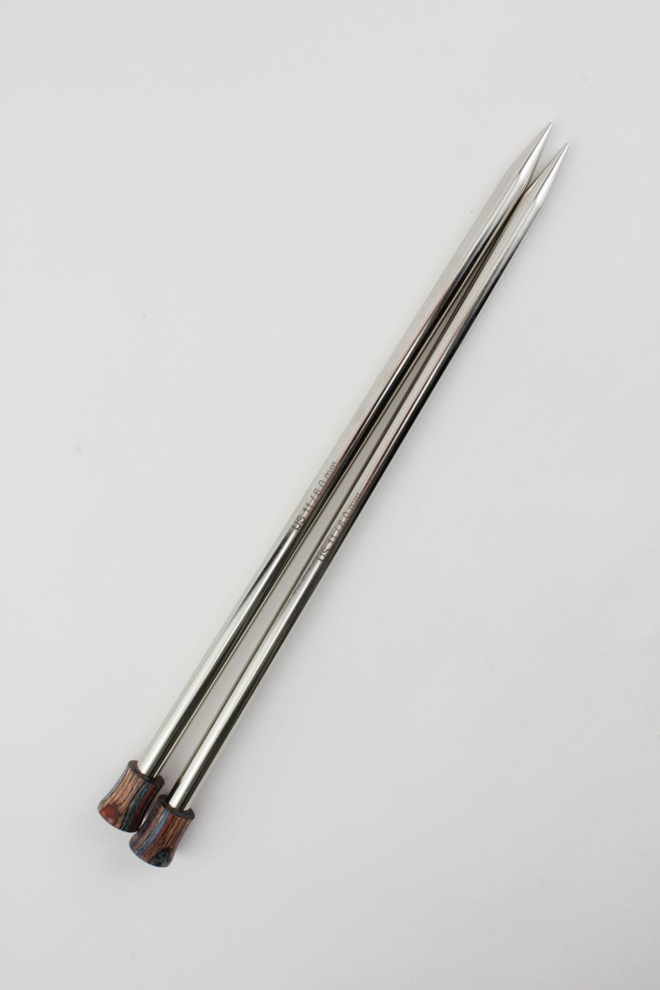 Three Knit Pro (Knitters Pride) Nova Metal Single Point Knitting Needles by Accessories Unlimited, 10" or 14", with pointed tips and wooden handles are arranged diagonally on a plain white background.