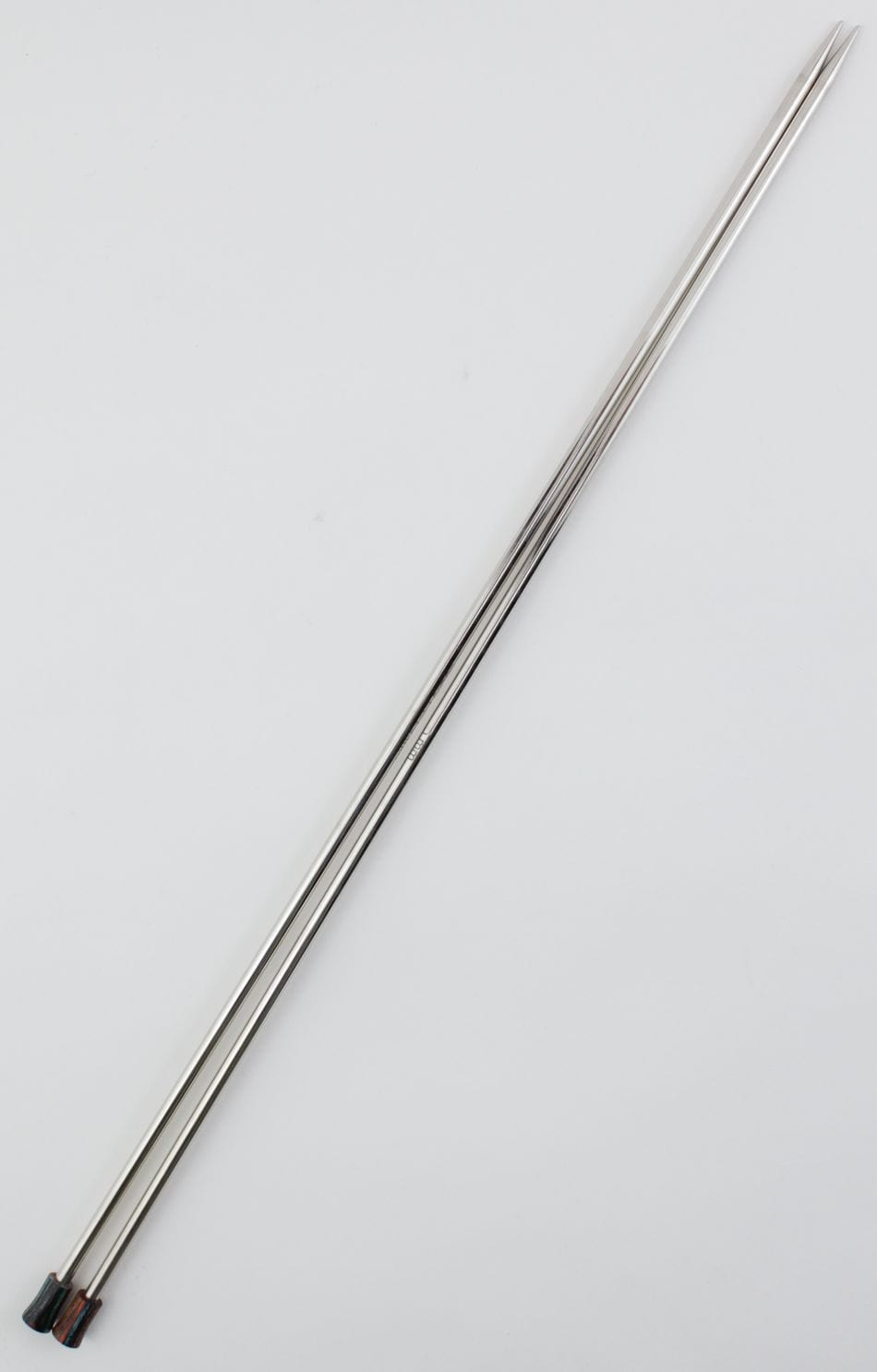 Two long Knit Pro (Knitters Pride) Nova Metal Single Point Knitting Needles, 10" or 14", by Accessories Unlimited, with pointed tips and black handles, are placed parallel on a plain background.