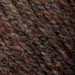 A close-up of Bartlettyarns' Bartlett Maine Wool Sport Weight Cones showcases soft, slightly fuzzy wool with varied strands and subtle multicolored flecks in red, blue, and yellow, enhancing its homespun appearance by highlighting intertwined fibers.