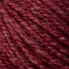 Close-up of Bartlett Maine Wool from Bartlettyarns shows soft, textured yarn in deep burgundy. The sport weight fibers are interwoven with a homespun appearance, creating a cozy and tactile feel.