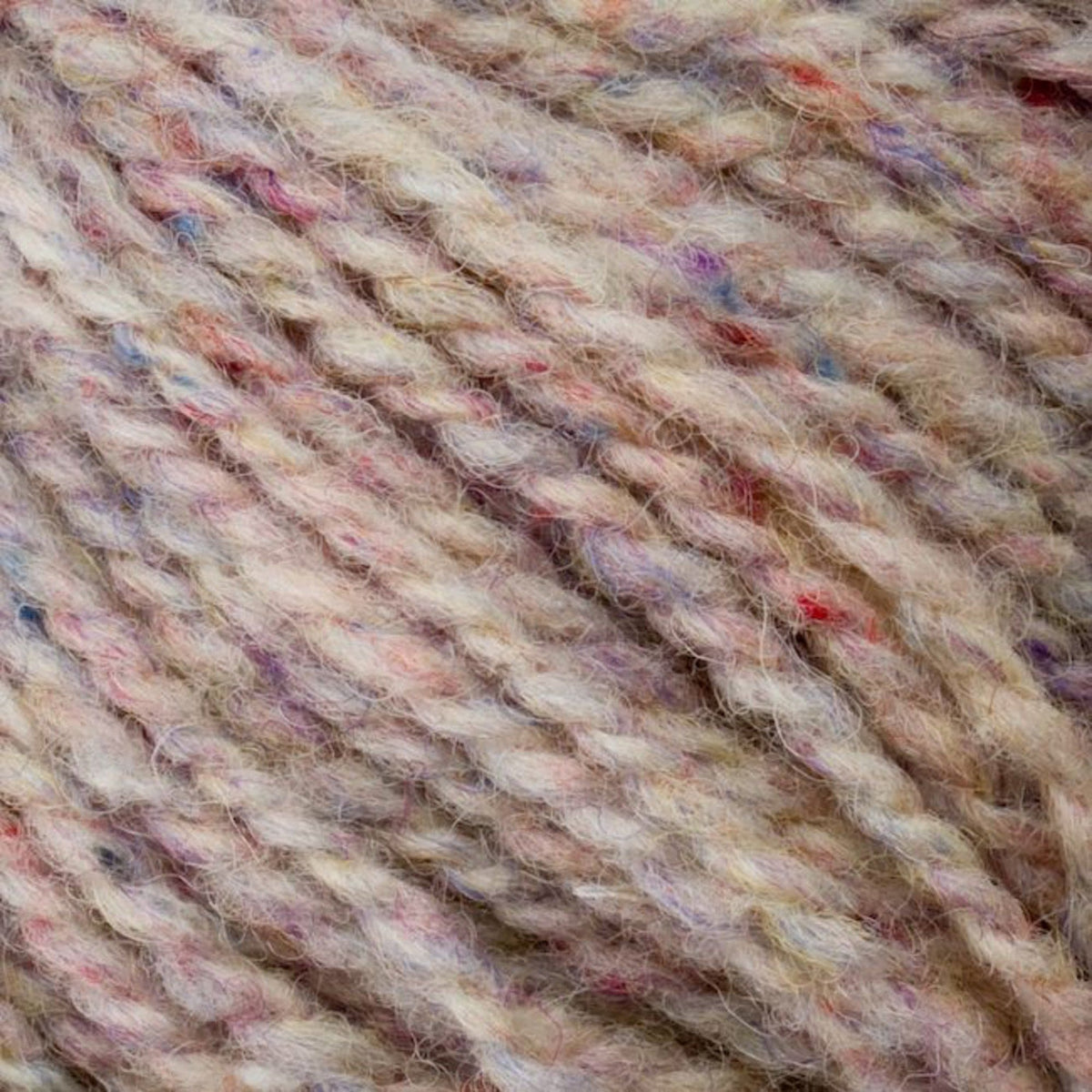 Close-up of Bartlettyarns' Bartlett Maine Wool, Sport Weight Cones in cream with hints of purple, pink, and blue. This yarn features a soft, textured homespun appearance with tightly twisted strands and colorful flecks for a cozy and intricate pattern.
