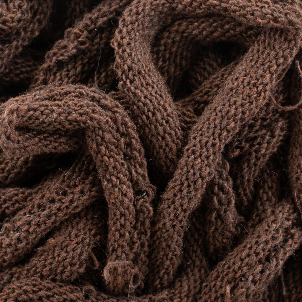 Close-up of tangled Harrisville Potholder Loops by Friendly Loom, showcasing intricate textures and loops resembling those crafted on a traditional loom. The image emphasizes the fibers and detailing of the knitting stitches.