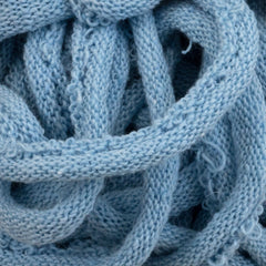 A close-up of the Harrisville Potholder Loops - Traditional Size by Friendly Loom, revealing its soft, light blue knitted fabric intricately looped and tangled like cotton loops on a traditional loom, elegantly showcasing its detailed texture.