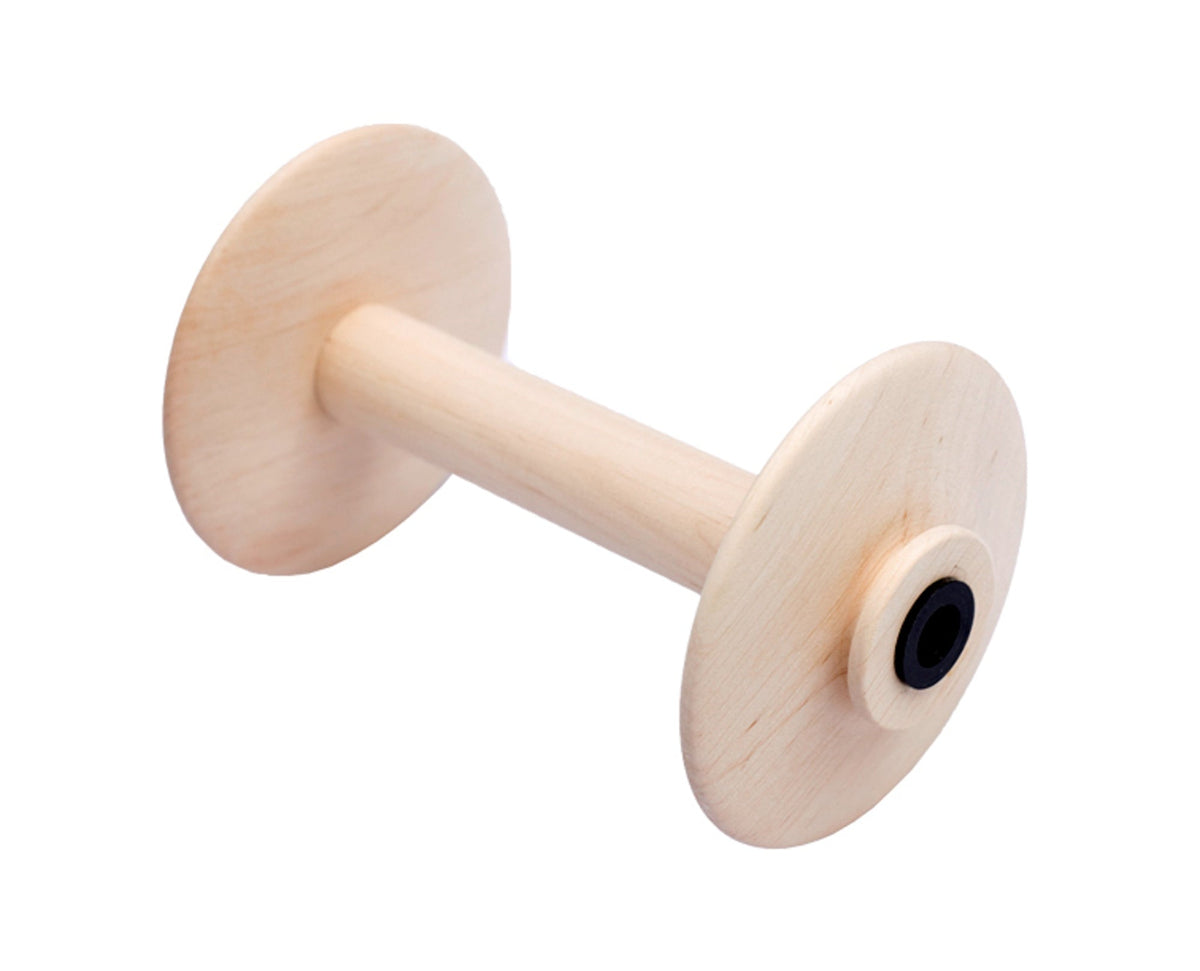 A Kromski North America Spinning Wheel Bobbin, light-colored wood with wide flat ends and a cylindrical center, is shown angled on a white background.